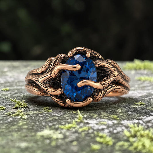 blue oval sapphire in a rose gold vine and branch wedding ring setting