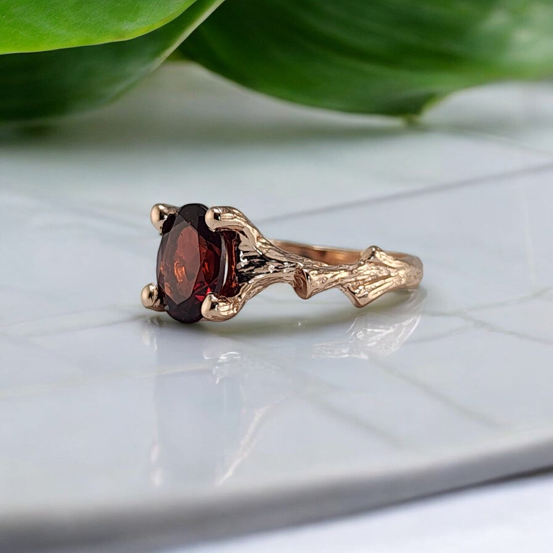 rose gold branch style ring with a oval garnet