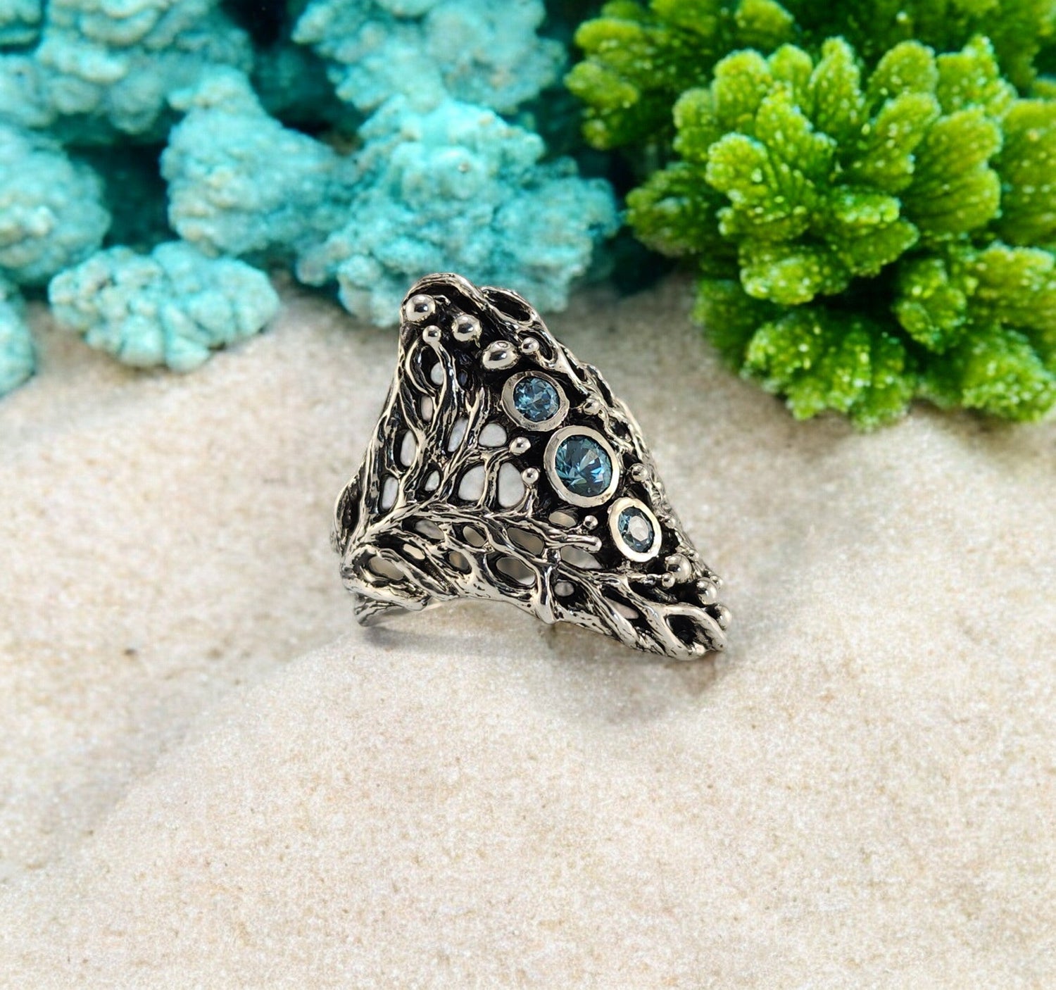 Silver coral ring with blue gemstones down the center