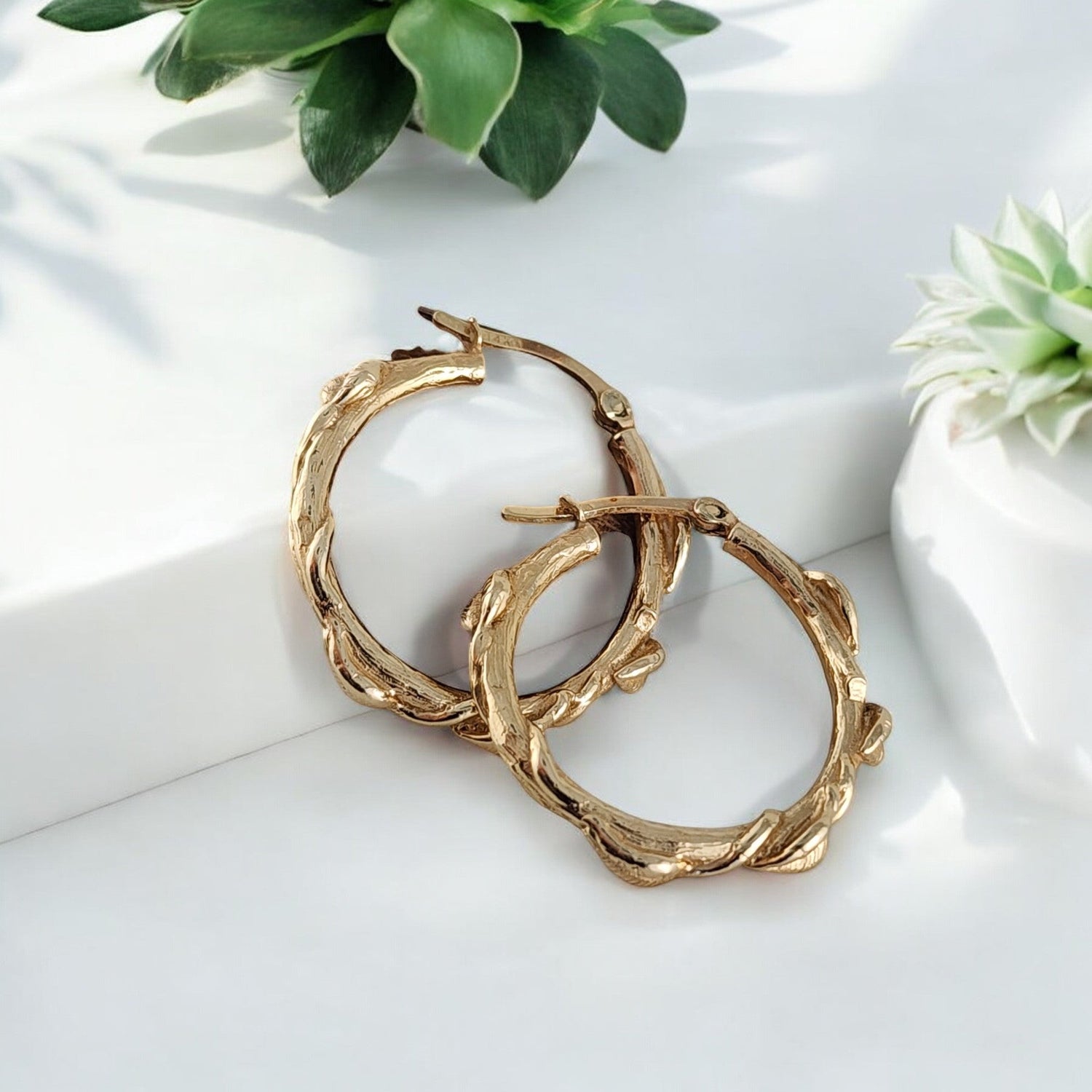 gold hoop earrings with leaves all around them