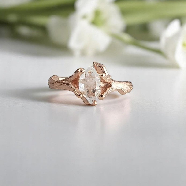 Rose gold ring with a herkimer diamond on a light background