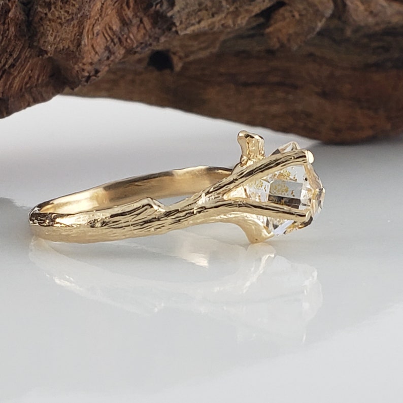 yellow Gold ring with a diamond on a white surface
