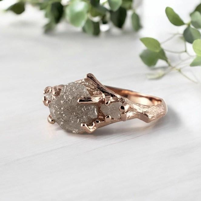 Rose gold ring with a raw rough diamond on a light background