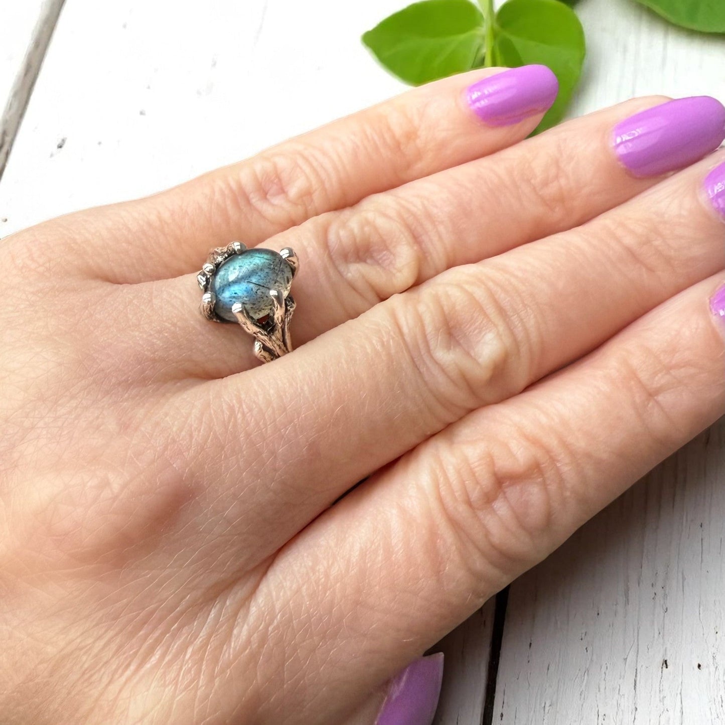 Labradorite sterling silver twig ring shown on a hand, nature-inspired solitaire with blue-green gemstone.